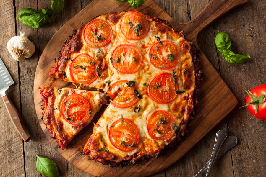 Cauliflower crust pizza with tomato and basil.