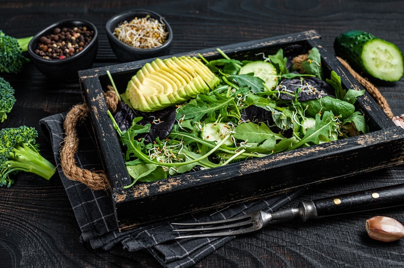 Green salad with salad leaves mix, avocado and vegetables.